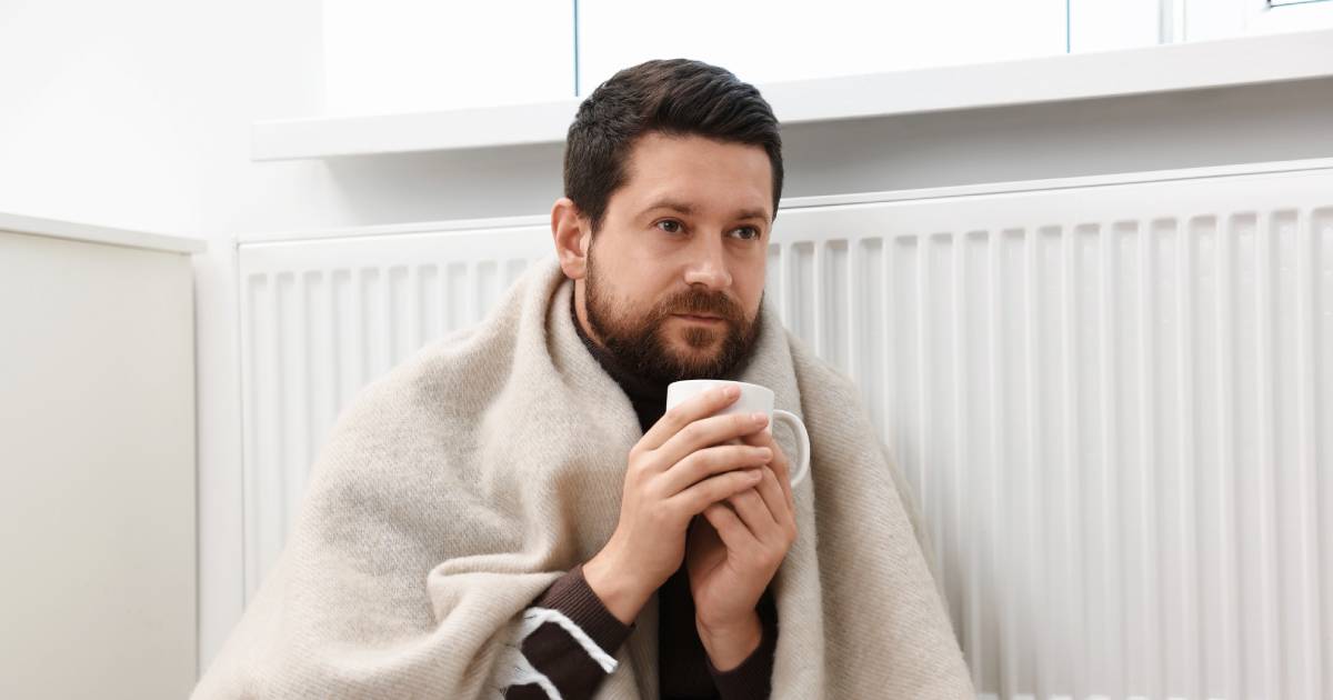 Homme se réchauffant avec un radiateur